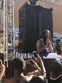 a man with dreadlocks on stage in front of a crowd