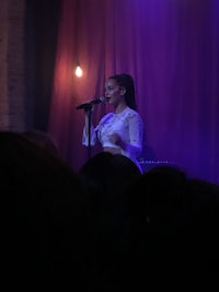 a woman singing into a microphone at a concert