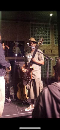 a man is playing a guitar in front of a crowd