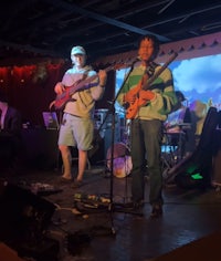 a group of people playing music on stage in front of a screen
