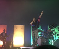 a man on stage with a guitar and drums
