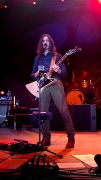 a man playing a guitar on stage
