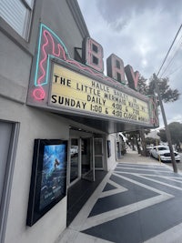 a movie theater with a sign that says the little mermaid