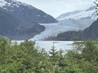 a glacier in the mountains with a lake in the background