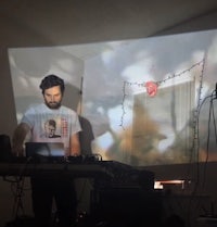 a man is playing a dj in front of a projection