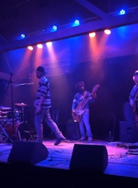 a group of people playing music on stage at night