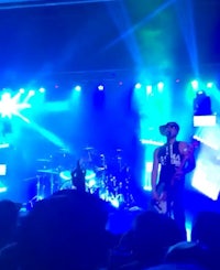 a group of people on stage at a concert with blue lights