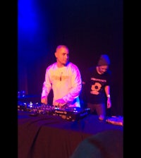 two djs standing in front of a dj booth